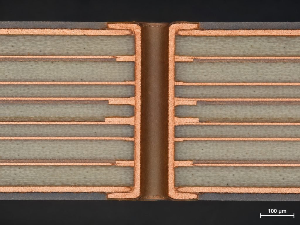 Cross-section micrograph of a multilayer RO4000 PCB showing stable plated through-holes, copper bonding, and dielectric layer structure for high-frequency circuit applications.