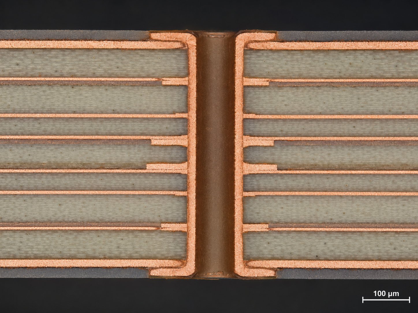 Cross-section micrograph of a multilayer RO4000 PCB showing stable plated through-holes, copper bonding, and dielectric layer structure for high-frequency circuit applications.